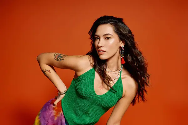 La mujer posa con confianza en un traje de moda sobre un brillante telón de fondo, exudando vibraciones de verano. — Stock Photo