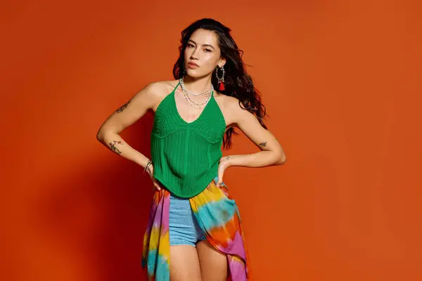 A confident young woman in vibrant summer attire radiates positivity against a warm backdrop. — Stock Photo