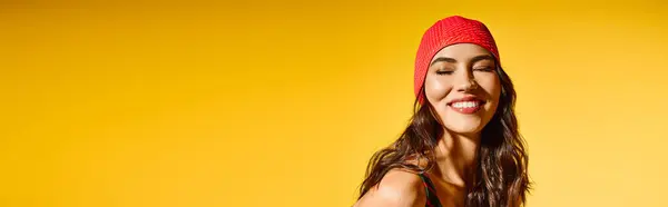 A young woman beams with joy in summer clothes, enjoying the warm sunshine and a bold backdrop. — Stock Photo
