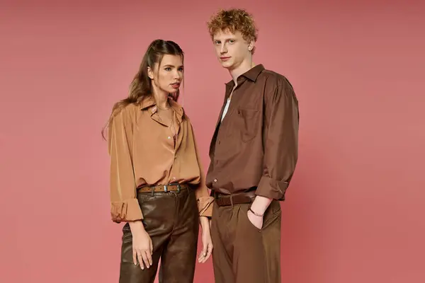 Two young people connect in trendy outfits against a vibrant backdrop. — Stock Photo