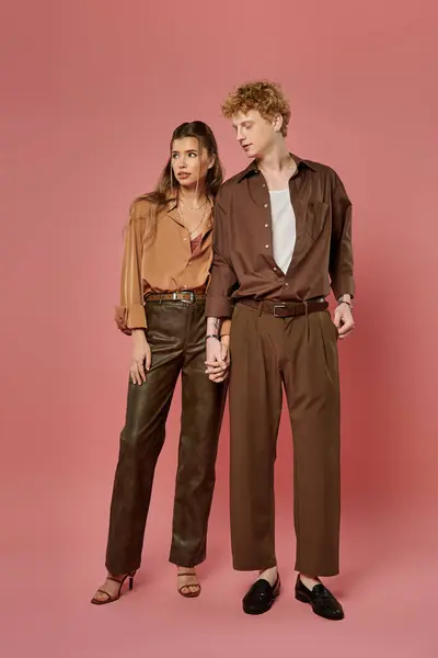 A young couple displays their love in stylish outfits against a chic pink backdrop. — Stock Photo