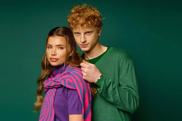 Young couple in stylish attire share a tender moment while showcasing their vibrant fashion sense. — Stock Photo