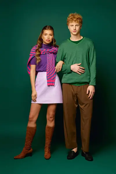 Couple flaunts trendy outfits and strong bond against a lush green backdrop in a photoshoot. — Stock Photo