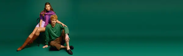 Elegante coppia posa insieme in uno sfondo verde moderno, irradiando amore e gioia attraverso la moda. — Foto stock