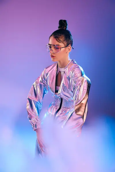 Eine stylische junge Frau steht inmitten wirbelnder leuchtender Farben in innovativer futuristischer Kleidung. — Stockfoto