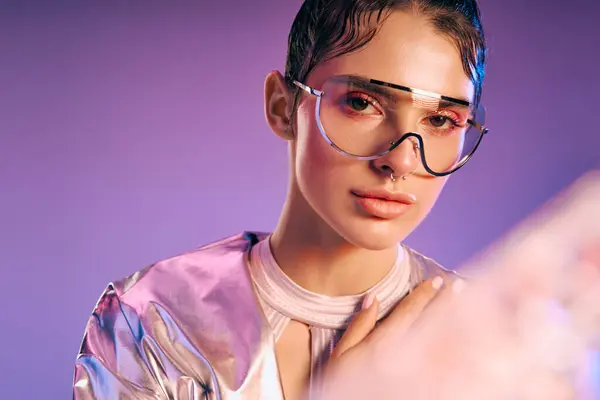 A young woman in metallic attire stands confidently against a vibrant backdrop, exuding modernity. — Stock Photo