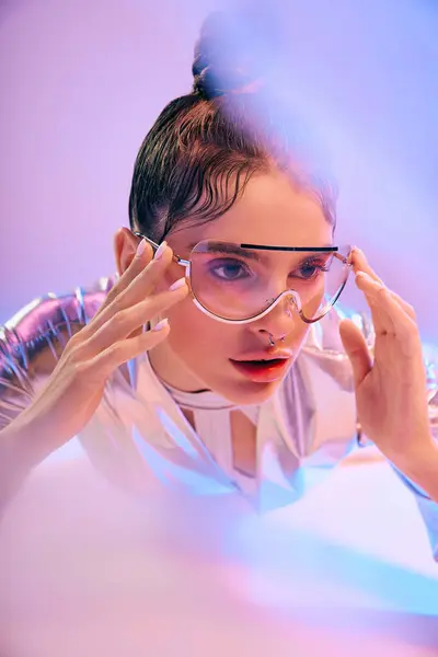 A young woman in metallic attire adjusts her glasses, embodying a futuristic style. — Stock Photo