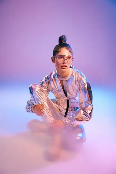 A stylish woman in metallic attire showcases a unique, vibrant look against a colorful backdrop. — Stock Photo