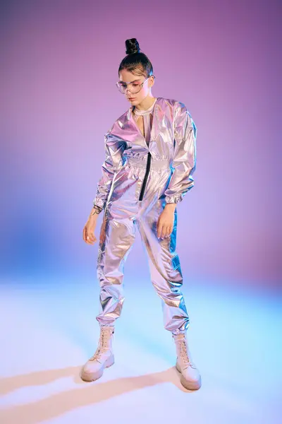 A young woman in holographic attire glows confidently under vibrant lights in a modern space. — Stock Photo