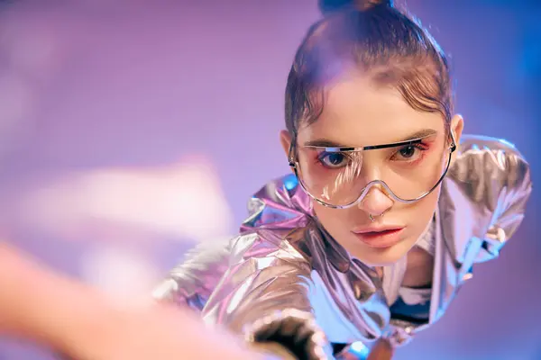 Stylish woman stuns in holographic and metallic fashion in a vibrant setting. — Stock Photo
