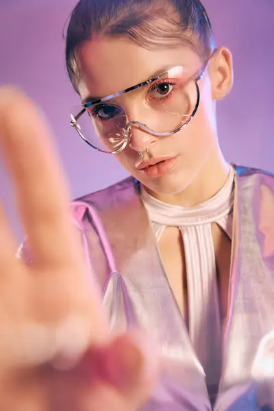 Young woman dressed in metallic attire captures attention with bold eyewear and holographic colors. — Stock Photo