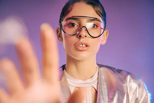 A young woman shows off her holographic outfit and unique accessories in a vibrant setting. — Stock Photo