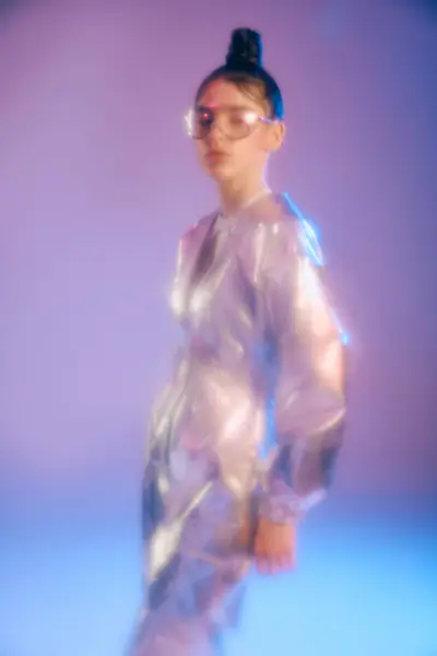 A young woman displays her chic holographic outfit in a vibrant, energetic space. — Stock Photo