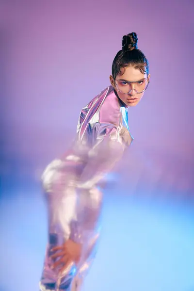 A young woman wears a vibrant holographic outfit, striking an artistic pose. — Stock Photo