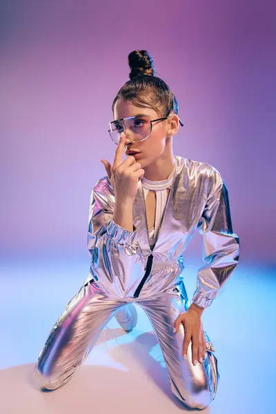 A young woman poses in a metallic outfit with vibrant holographic colors against a bold backdrop. — Stock Photo