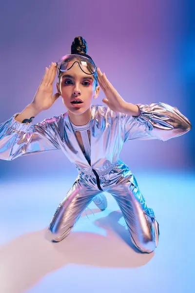 A stylish woman in a holographic outfit poses dynamically, radiating youthful energy. — Stock Photo