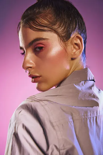 Stylish individual exudes confidence in fashionable attire with a mesmerizing holographic backdrop. — Stock Photo