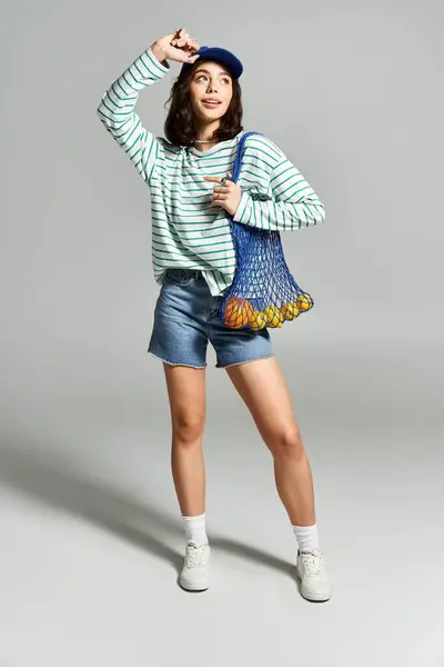 Jeune femme brillamment habillée met en valeur la mode estivale avec une pose ludique et une expression joyeuse — Photo de stock