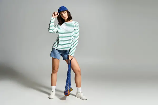 Une jeune, belle femme porte des vêtements d'été tendance tout en posant avec une expression ludique à l'intérieur. — Photo de stock