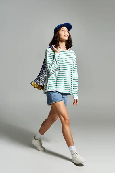 Jeune femme jouit d'une promenade insouciante en tenue d'été à la mode, style exubérant et confiance. — Photo de stock