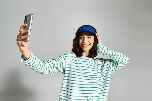 A cheerful young woman in stylish summer attire joyfully takes a selfie with a bright smile. — Stock Photo