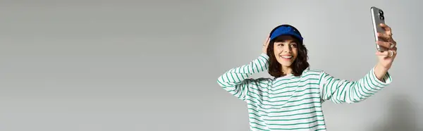 Une jeune femme joyeuse en vêtements d'été tendance pose pour un selfie, rayonnant de bonheur et de style. — Photo de stock