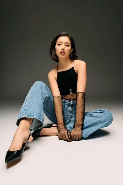 Stylish woman sits gracefully on floor wearing trendy outfit exuding confidence and elegance — Stock Photo