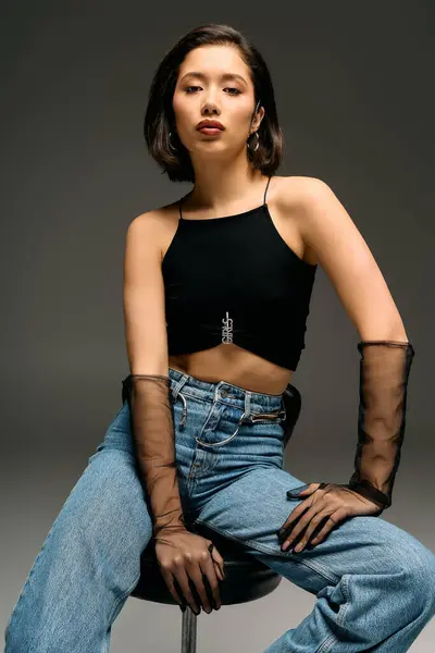 Jovem mulher confiante apresenta moda moderna com top único e acessórios elegantes em estúdio. — Fotografia de Stock