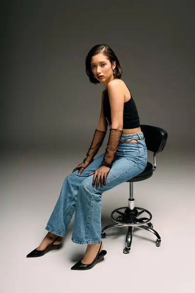 Uma mulher elegante com um olhar nervoso senta-se confiantemente em um estúdio moderno. — Fotografia de Stock