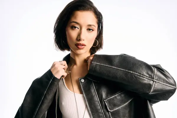 A young woman displays her unique style in a black jacket against a clean backdrop. — Stock Photo