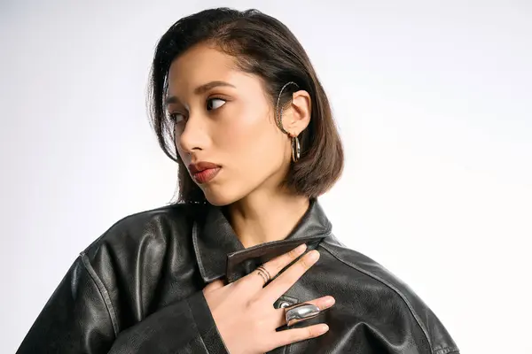 Fashionable young woman poses elegantly with an edgy outfit in a bright studio setting. — Stock Photo