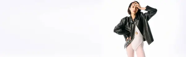 A confident young woman in a black leather jacket strikes a pose while expressing her unique style. — Stock Photo