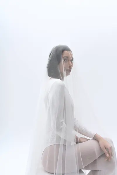 A young bride exudes grace wearing a delicate veil, creating a moment of beauty and tranquility. — Stock Photo