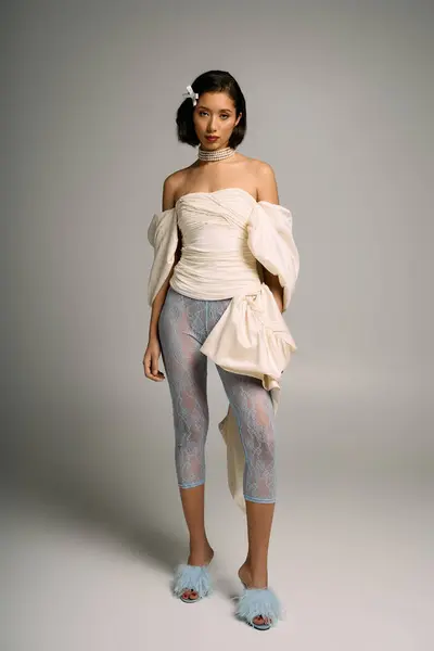 A young bride stands confidently, showcasing beauty in a soft hued, avant garde outfit. — Stock Photo