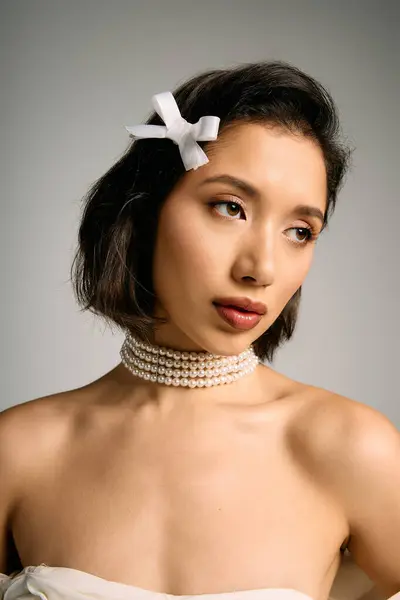 Una mujer irradia encanto mientras posa con gracia, destacando su belleza nupcial en una iluminación suave. - foto de stock