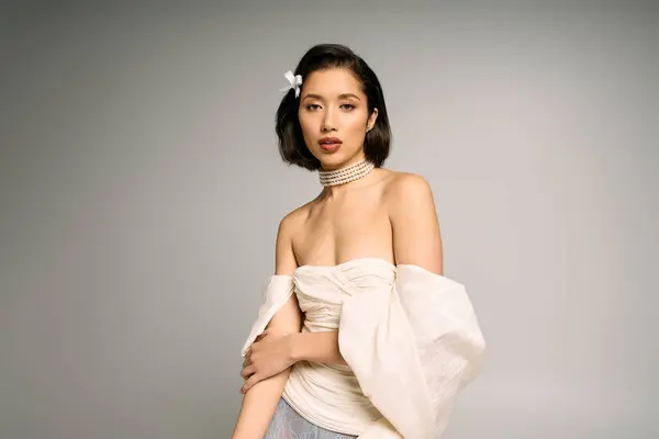 Young bride showcases her stunning beauty with a chic outfit and delicate flower in her hair — Stock Photo