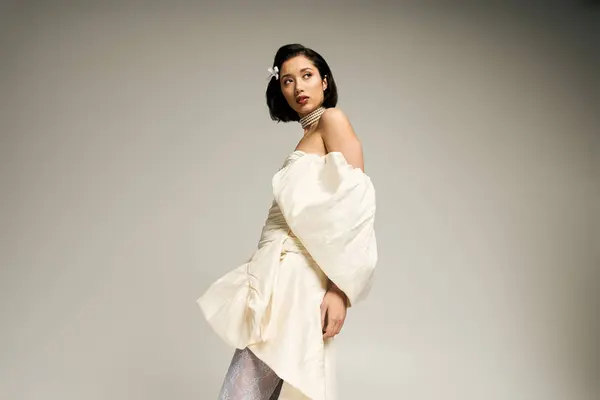 A stunning young bride poses elegantly in a graceful gown, highlighting her beauty and poise. — Stock Photo