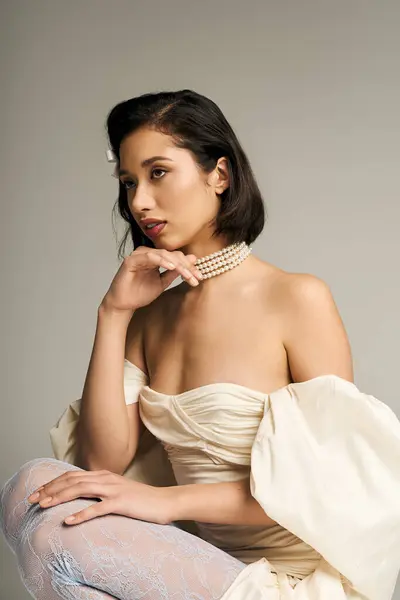 A graceful young bride gazes thoughtfully, adorned in elegant attire and delicate accessories. — Stock Photo