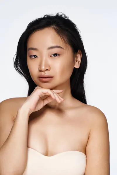 Una giovane donna asiatica mostra elegantemente la sua bellezza, affascinando lo spettatore in un momento sereno. — Foto stock