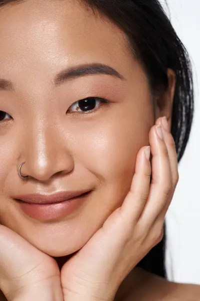A young asian woman displays confidence with a radiant smile and gentle pose, radiating beauty. — Stock Photo
