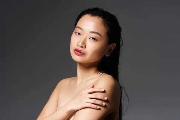 Capturée dans un studio serein, une jeune femme asiatique met en valeur sa beauté rayonnante et son équilibre. — Photo de stock