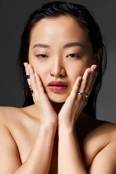 Una giovane donna asiatica trasuda fiducia ed eleganza, mostrando la sua bellezza e la sua arte in uno studio. — Foto stock