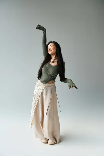 A dancer with long hair in a graceful outfit moves joyfully in an artistic studio. — Stock Photo