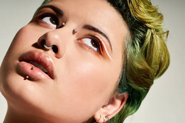 A young woman with colorful hair and artistic makeup gazes upwards, embodying style and creativity. — Stock Photo