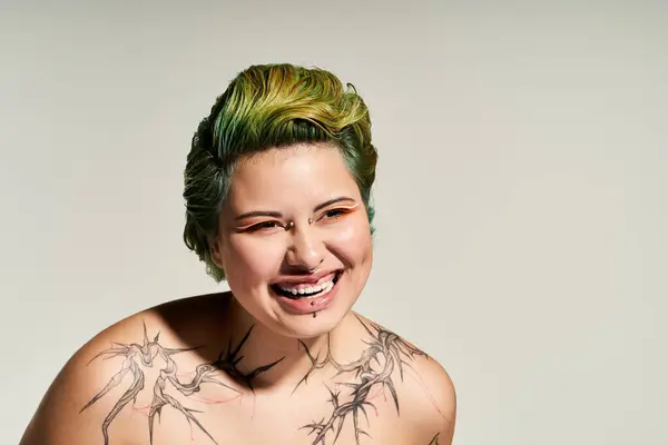 Vibrant hair complements a joyful young woman with striking tattoos and chic makeup. — Stock Photo