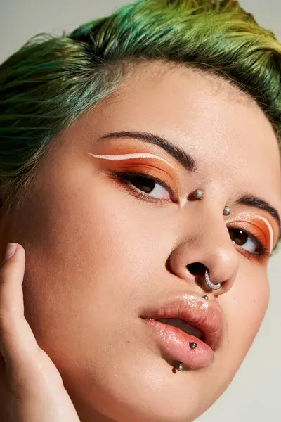 A young woman with bold green hair and edgy makeup showcases her vibrant style. — Stock Photo