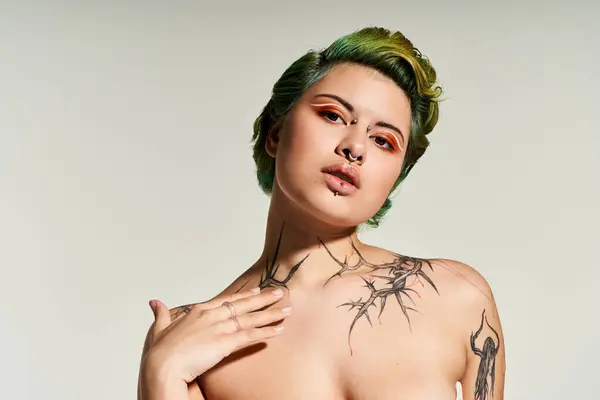 Confident woman with unique tattoos captivates the camera in a contemporary fashion space. — Stock Photo