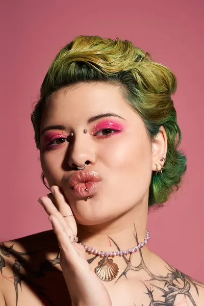 A young woman shows off vibrant pink makeup and a unique hairstyle against a pink background. — Stock Photo