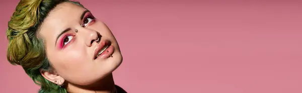 Vibrant woman with bold makeup and colorful hair poses confidently in a chic fashion display. — Stock Photo