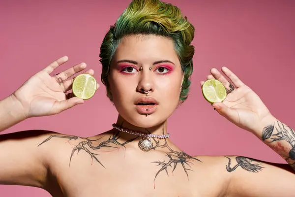 A young woman flaunts her unique style with citrus halves against a pink backdrop. — Stock Photo
